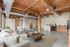 Spacious industrial-chic apartment featuring a cozy living area, modern kitchen, and stylish wood beam ceiling with exposed ductwork.