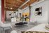Modern loft apartment featuring exposed wooden beams, stylish open kitchen, and elegant living space with contemporary artwork.