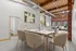 Contemporary open-concept dining area with elegant marble table, chic beige chairs, and industrial-style exposed wooden beams and ducts.