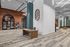 Modern spacious lobby with stylish brick accent walls, sleek lighting, and chic furnishings in a vibrant office space.