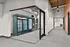 Modern hallway with glass doors revealing a sleek vending and refreshment area with beverages and snacks.
