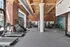 Modern gym with brick walls featuring state-of-the-art fitness equipment, spacious layout, and natural light.