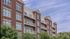 Elegant brick apartment building with spacious balconies and large windows.