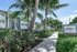 Modern apartment complex surrounded by lush palm trees and vibrant foliage.