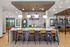 Elegant apartment lobby featuring a stylish seating area with modern lighting, colorful accents, and a sleek coffee bar.