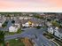Aerial view of a charming residential community at sunset, showcasing modern townhouses and lush greenery in a serene neighborhood.