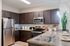 Modern kitchen with sleek granite countertops, stainless steel appliances, and elegant dark wood cabinetry, perfect for culinary inspiration.