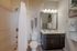 Elegant bathroom featuring modern fixtures, sleek dark wood cabinetry, and stylish decor accents.