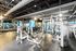 Modern fitness center with state-of-the-art gym equipment, mirrors reflecting the spacious and well-lit workout area.