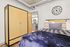 Chic bedroom featuring a cozy bed with plush pillows, stylish industrial details, and a modern wardrobe.