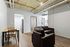 Chic industrial-style apartment with exposed ductwork, featuring a cozy living area, modern kitchenette, and space-efficient dining corner.