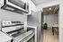 Modern kitchen with sleek stainless steel appliances, adjacent to a cozy dining area in a stylish apartment.