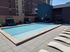 Luxurious rooftop swimming pool with stylish lounge chairs and cozy cabanas, perfect for relaxation and city views.