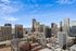 Stunning panoramic view of a vibrant city skyline with modern skyscrapers under a clear blue sky.