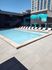 Luxurious apartment pool area featuring sleek lounge chairs and a vibrant mural, perfect for relaxation and city views.