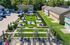Inviting communal courtyard with manicured lawns, stylish seating areas, and shaded picnic tables, surrounded by modern townhouse units.