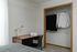Cozy bedroom with a stylish desk and neatly organized closet space, perfect for comfortable living and productivity.