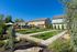 Charming residential area with modern townhouses, lush green lawns, and inviting picnic spaces beneath large umbrellas.