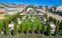 Beautiful landscaped garden with lush green grass, hammocks, and picnic areas surrounded by charming townhouses.