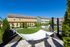 Charming backyard oasis with luxurious hammocks, vibrant green lawn, and sunny patio area for ultimate relaxation.