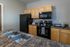 Modern kitchen with sleek black appliances, stylish wooden cabinets, and polished countertops, ideal for culinary creativity.