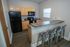 Modern kitchen with sleek appliances, wood cabinetry, and a stylish breakfast bar, perfect for entertaining.