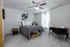 Bright and cozy bedroom featuring a stylish ceiling fan, modern art, and a functional desk space.