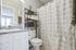 Bright and modern bathroom featuring elegant white cabinetry, sparkling granite countertop, and a stylish shower curtain.
