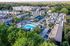 Charming residential complex with modern townhouses, vibrant green spaces, and an inviting outdoor pool area. A perfect blend of comfort and community amidst lush greenery.