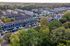 Charming aerial view of a vibrant apartment community surrounded by lush greenery and ample parking, perfect for serene living.