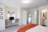 Inviting bedroom with cozy workspace, modern ensuite bathroom, and elegant decor.