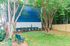 Charming outdoor space with lush greenery and cozy bench seating next to a vibrant blue building.