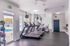 Bright and modern fitness center with treadmills, exercise bikes, and a view of the outdoor pool.