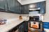 Sleek modern kitchen with elegant dark blue cabinets, stylish granite countertops, and high-end stainless steel appliances.