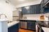 Modern kitchen with sleek dark cabinets, stainless steel appliances, and elegant granite countertops, perfect for culinary enthusiasts.