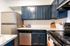 Modern kitchen with sleek stainless steel appliances, elegant dark cabinetry, and chic marble countertops.