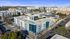 Aerial view of a modern apartment complex with sleek architecture and vibrant surroundings, offering a desirable urban living experience.