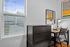 Bright and modern workspace with a sleek desk, comfortable chair, and large window showcasing a courtyard view.