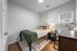 Cozy bedroom featuring a comfy bed with stylish pillows, modern desk setup, and elegant lighting, perfect for a relaxing retreat.