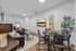 Stylish modern living room with cozy seating, vibrant wall art, and a dining area, perfect for relaxation and entertaining.