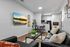 Contemporary living room and kitchen area with sleek black leather sofas, modern decor, and a stylish dining set, perfect for relaxation and entertainment.
