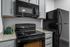 Modern kitchen featuring sleek black appliances, elegant granite countertops, and contemporary cabinetry for a stylish touch.