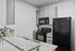 Modern kitchen with sleek black appliances, granite countertops, and stylish cabinetry, perfect for culinary enthusiasts.