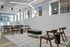 Chic office space featuring modern wooden seating, sleek conference table, and large windows providing natural light.