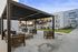 Modern outdoor lounge area with sleek pergola, stylish wooden furniture, and ample seating, ideal for relaxation and social gatherings.