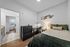 Inviting bedroom with chic decor, cozy bedding, and a well-lit workspace, featuring a sleek dresser and modern design elements for a stylish living experience.