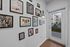 Chic entryway adorned with vibrant art gallery wall, leading to a sunlit outdoor balcony with modern apartment view.
