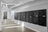 Modern apartment building hallway with sleek mailboxes and contemporary lighting.