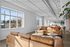 Bright and airy modern living space with stylish leather sofas, large windows, and sleek minimalist decor.