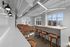 Contemporary open-concept lounge area with modern lighting, stylish bar seating, and plush leather couches, bathed in natural light from expansive windows.